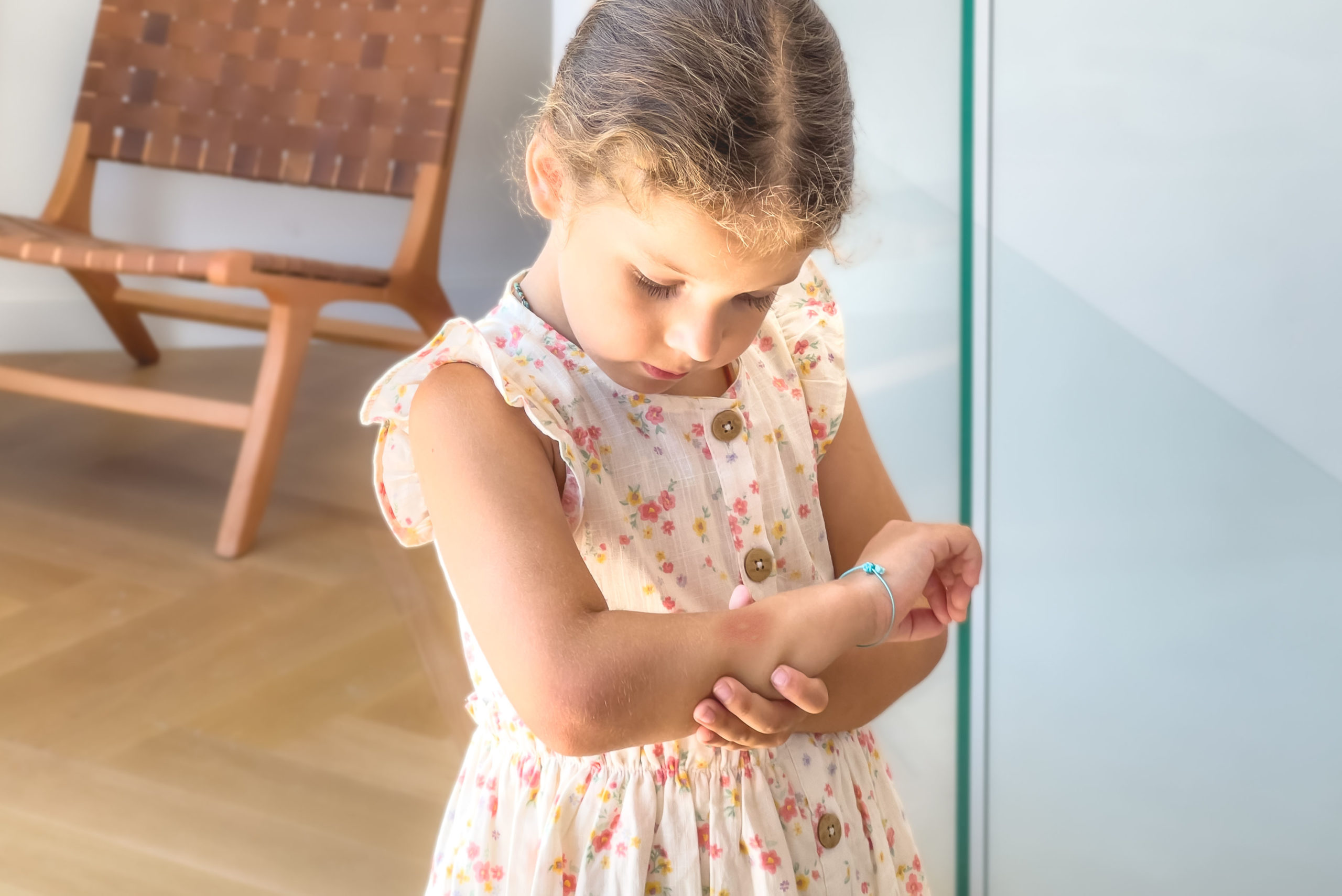 Küçük kızı sivrisinek ısırmış kolunu tutuyor ve kaşıyor