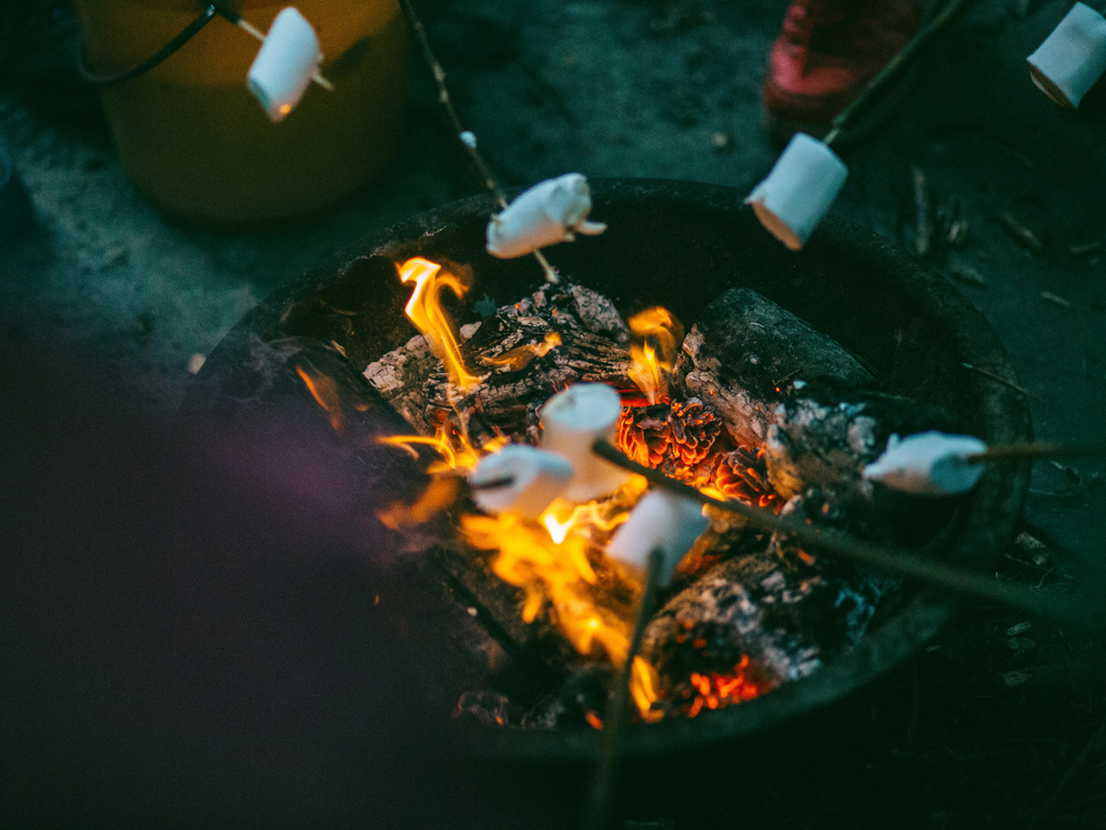 Alaçatı Delikli Koy kamp ateşi etrafında marshmellow yiyen gençler