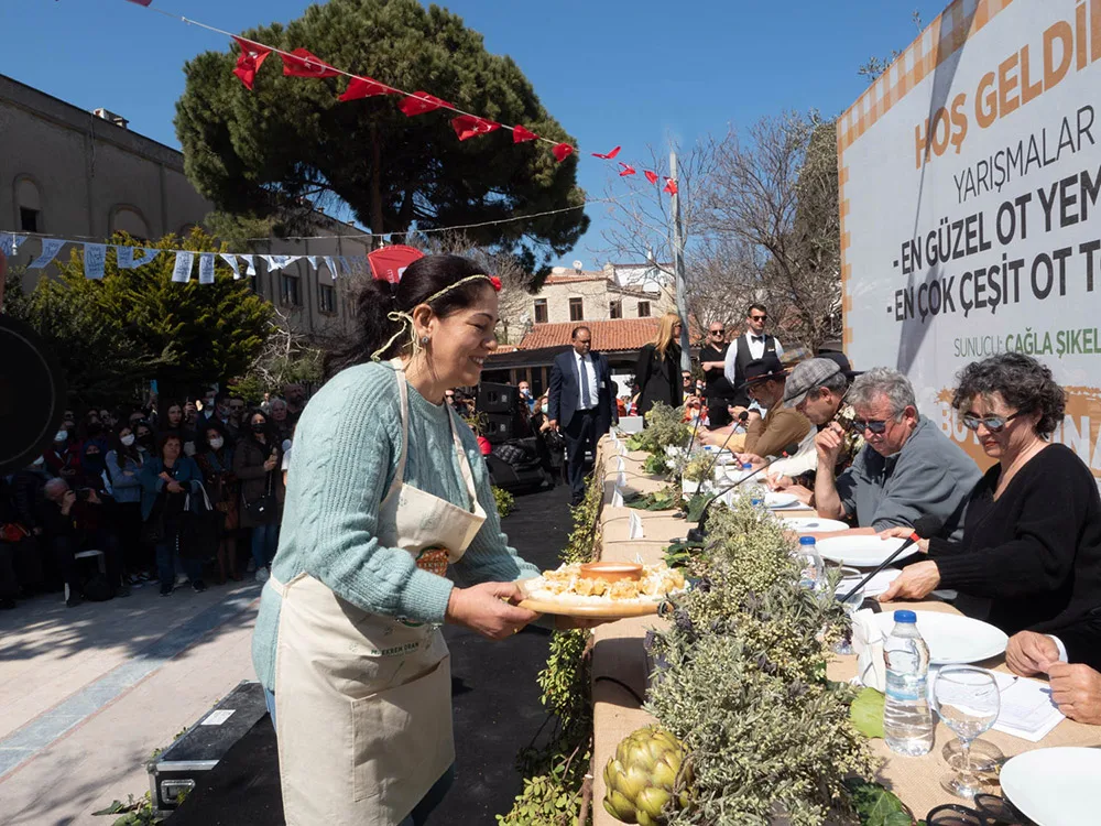 Alaçatı Ot Festivalinde yapılan yemek yarışmasında, yaptığı yemeği özenle sunan yarışmacı