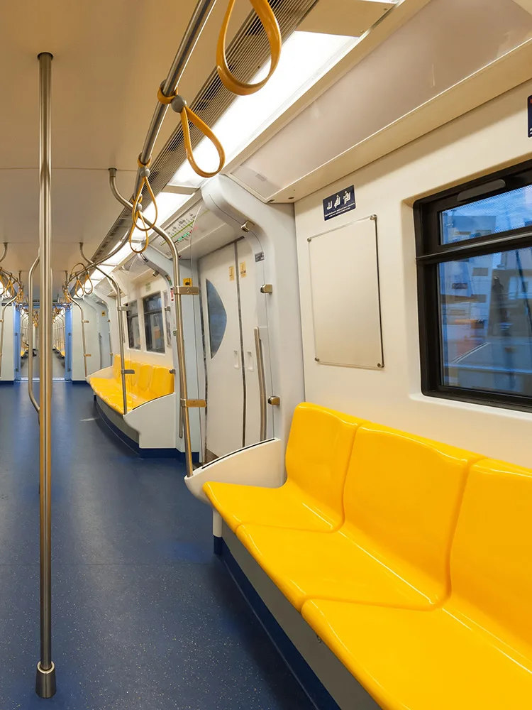 sarı koltukları ve demir tutunma alanları olan metronun içerden görüntüsü