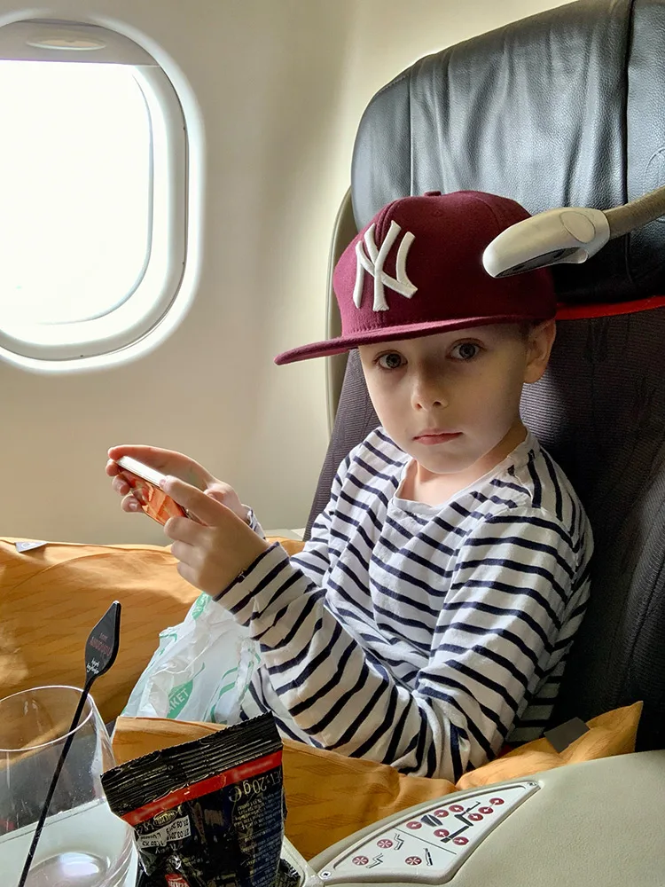 Uçakta kırmızı şapkalı yakışıklı çocuk yolcu