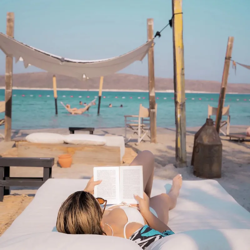 Beach clublar Plage İsolee Alaçatı'nın sessiz atmosferinde huzurla kitap okuyan insan