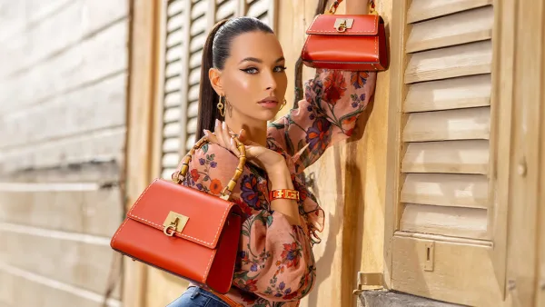 Guess markasının çanta kreasyonu kapak çekimi güzel kadın elinde 2 tane kırmızı çanta tutuyor