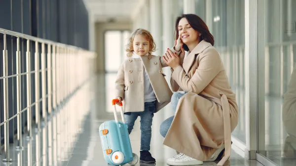 Çocuğu ile yolculuk yapan bir anne havaalanında küçük kızıyla uçakları izliyorlar