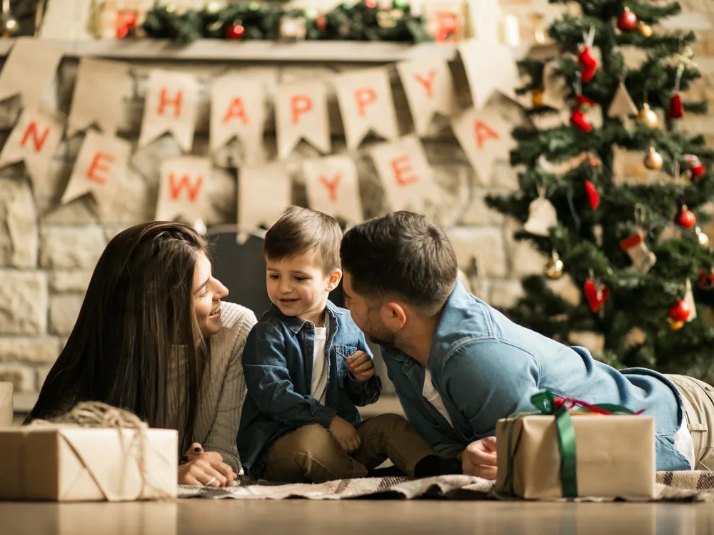 Yılbaşı ağacının altında hediyelerini açan sevimli aile