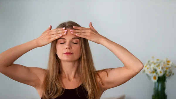 Alnındaki kırışıklıklar için yoga yapan kadın rahatlamaya çalışıyor
