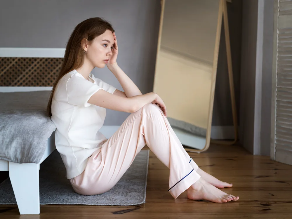 bahar depresyonu ile baş etmeye çalışan kadın odasında oturarak boş boş bakıyor