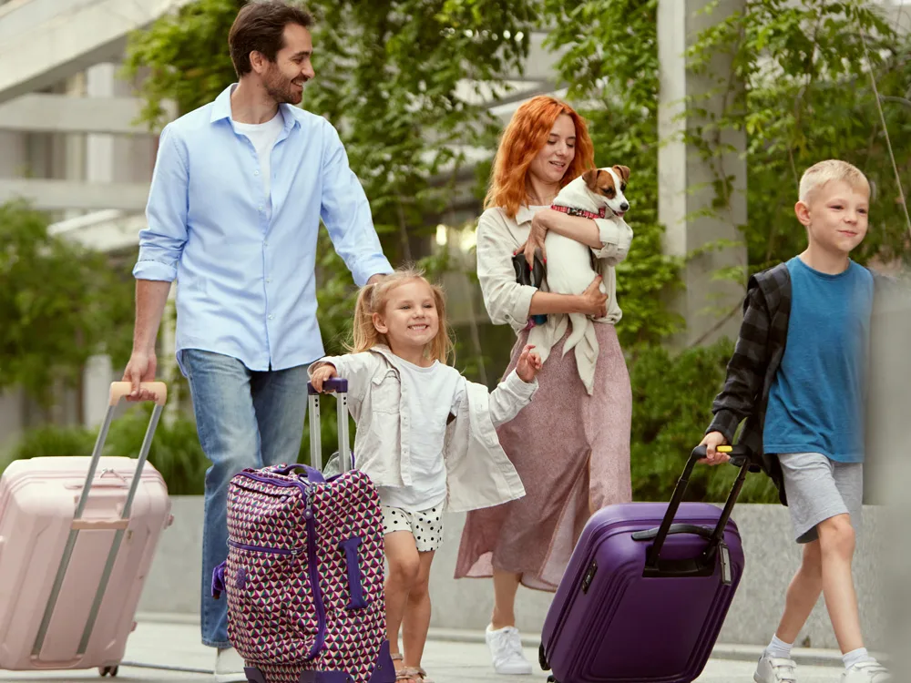 ailecek seyahat için valizleriyle yola çıkan anne, baba ve 2 çocuk
